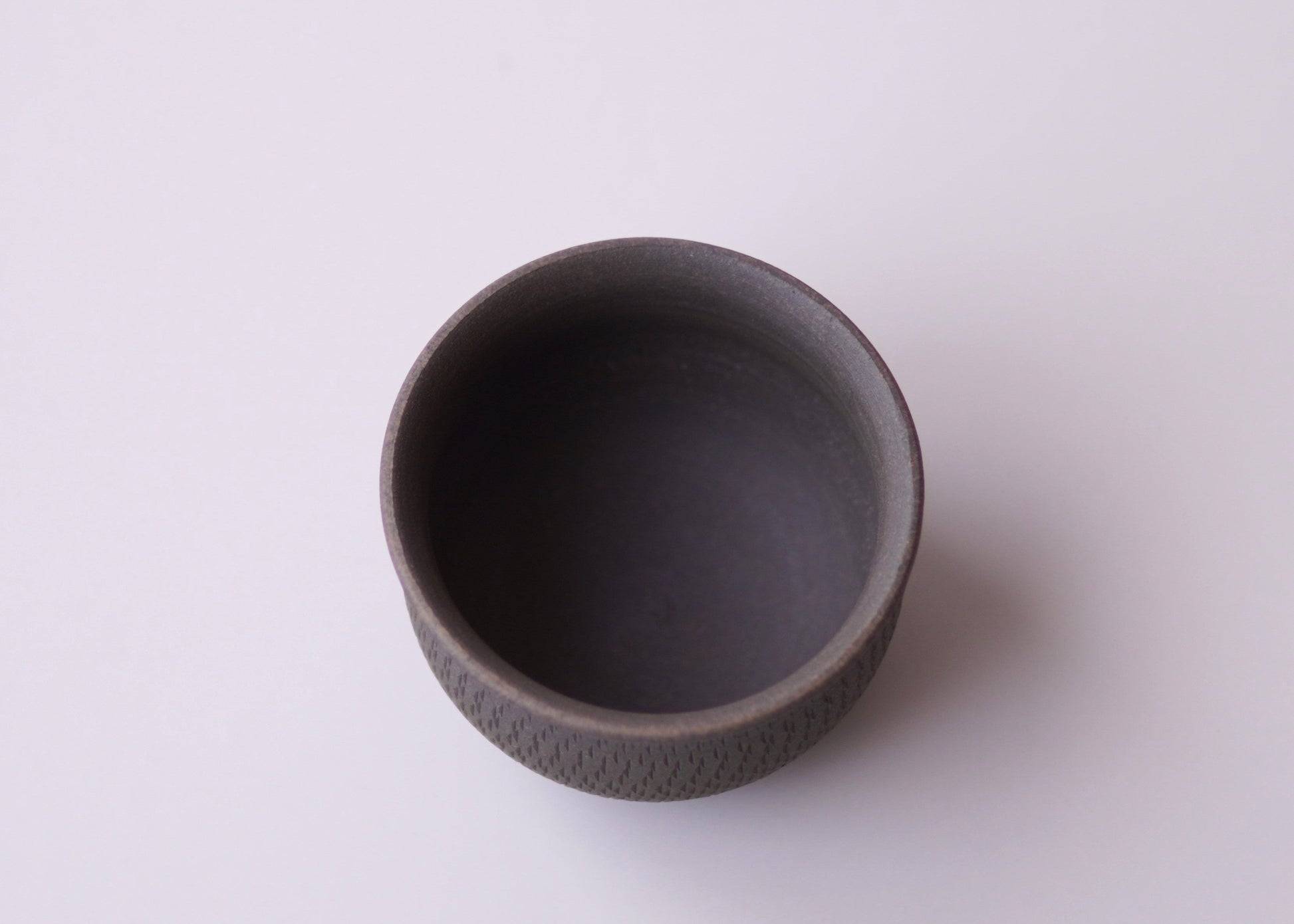 Dark gray ceramic cup on a light gray background