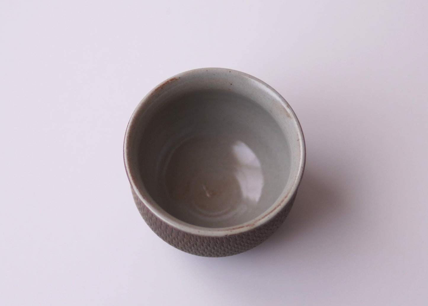 Ceramic cup with textured exterior on a white background
