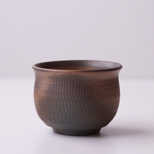 Textured ceramic cup on a white background