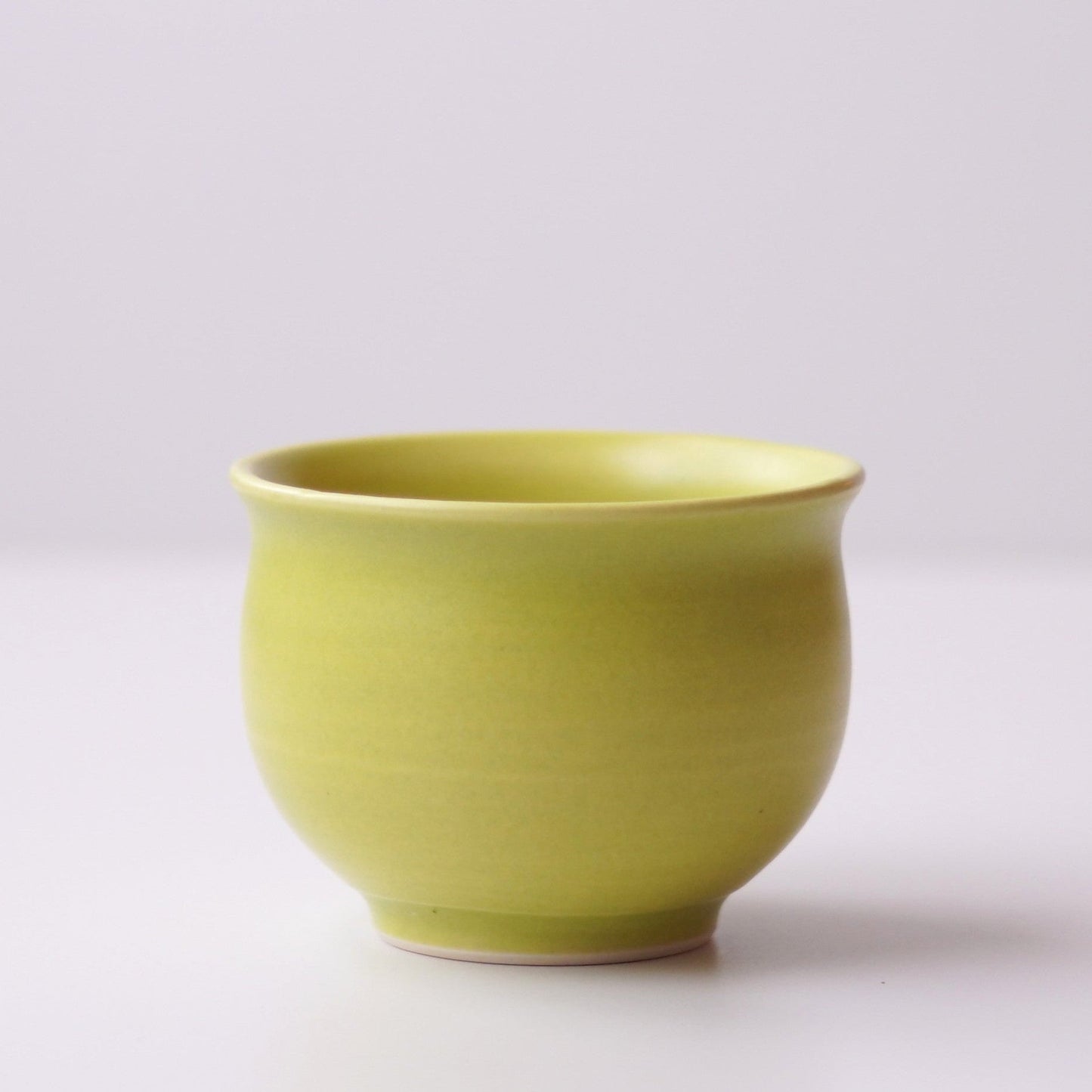 Green ceramic cup on a white background