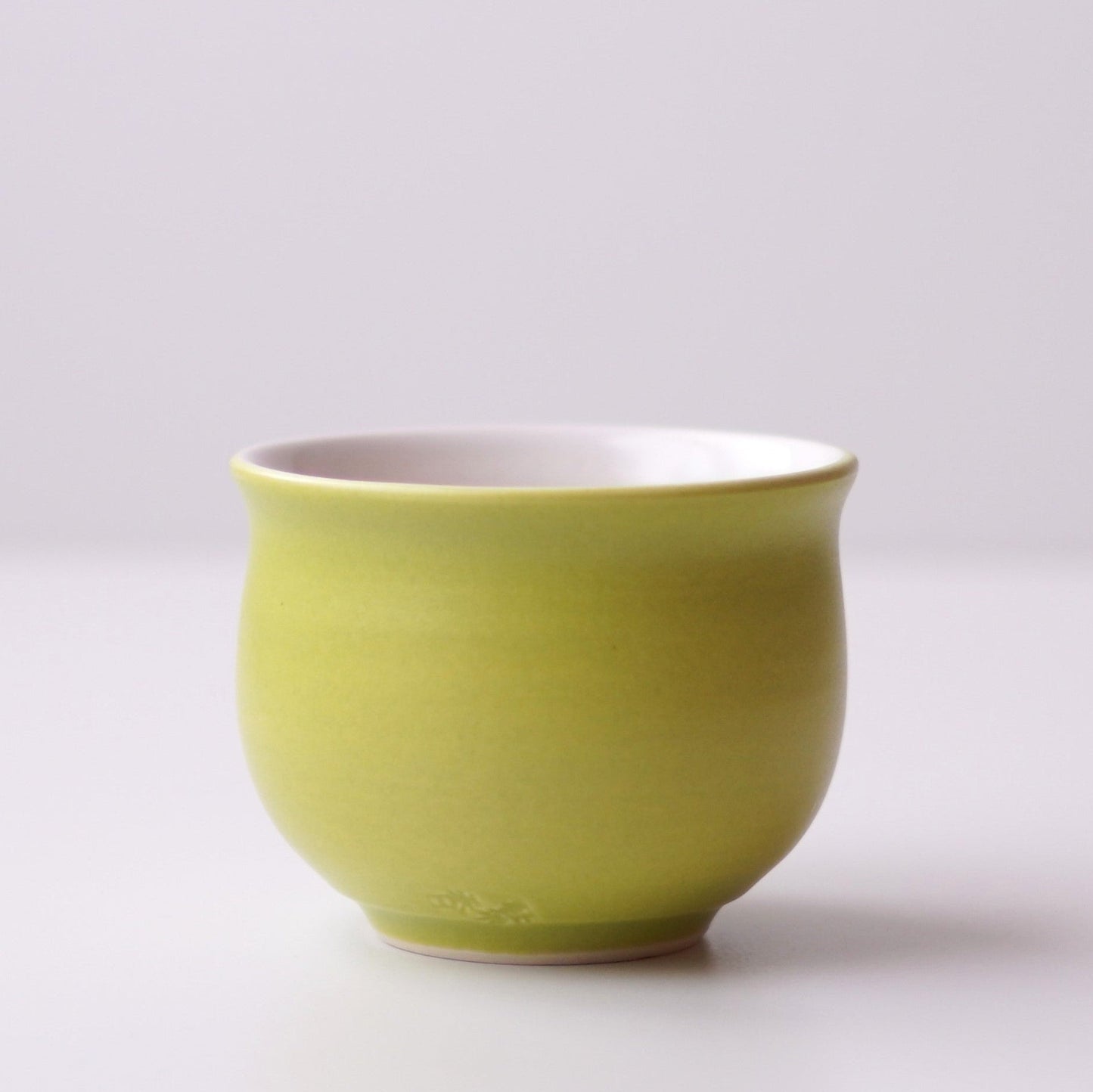 Green ceramic cup on a white background