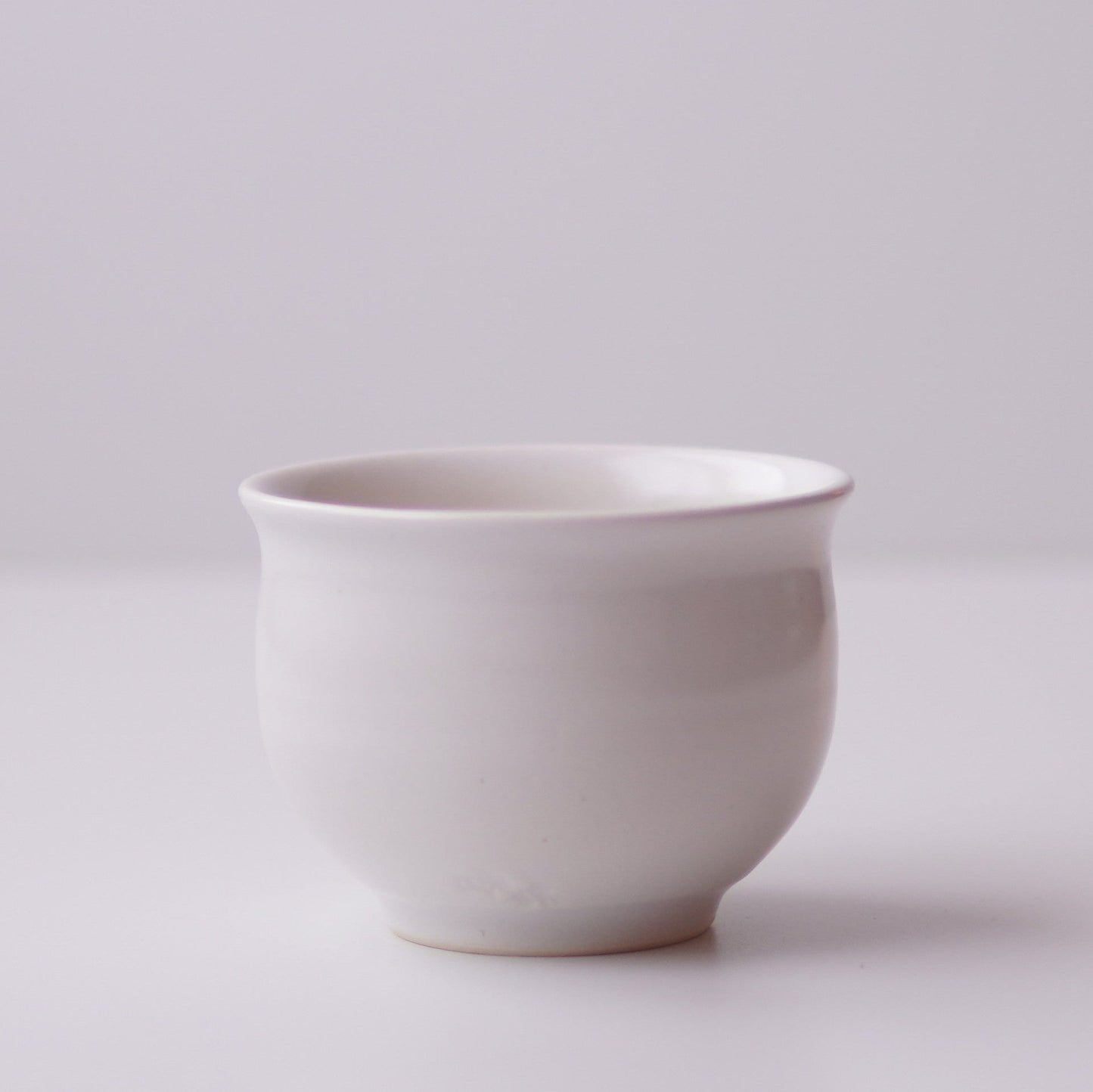 White ceramic cup on a light gray background